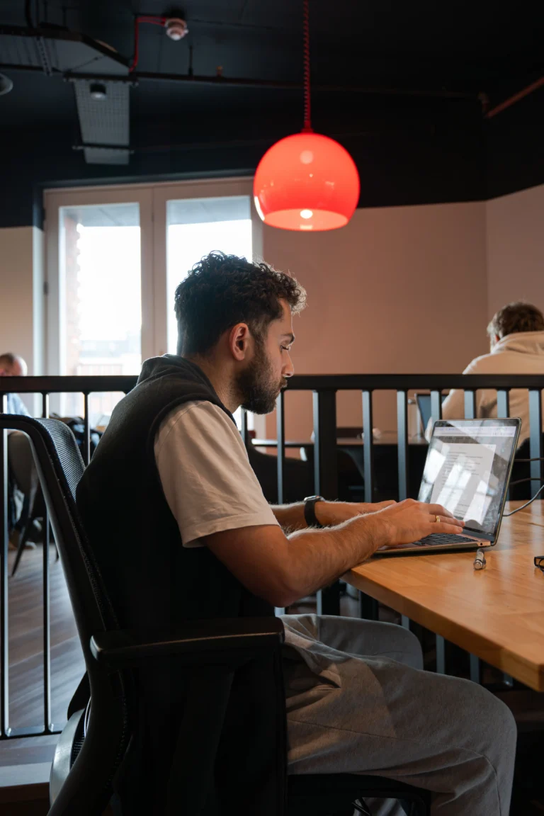 Member working on a laptop at a coworking desk